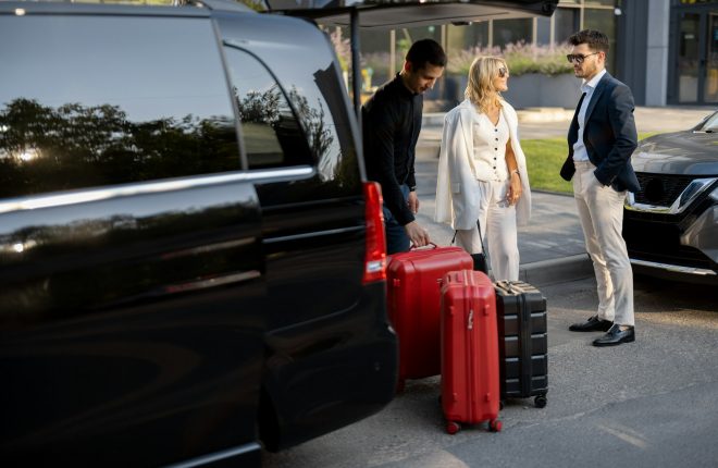 Business couple near minivan taxi with a suitcases and chauffeur